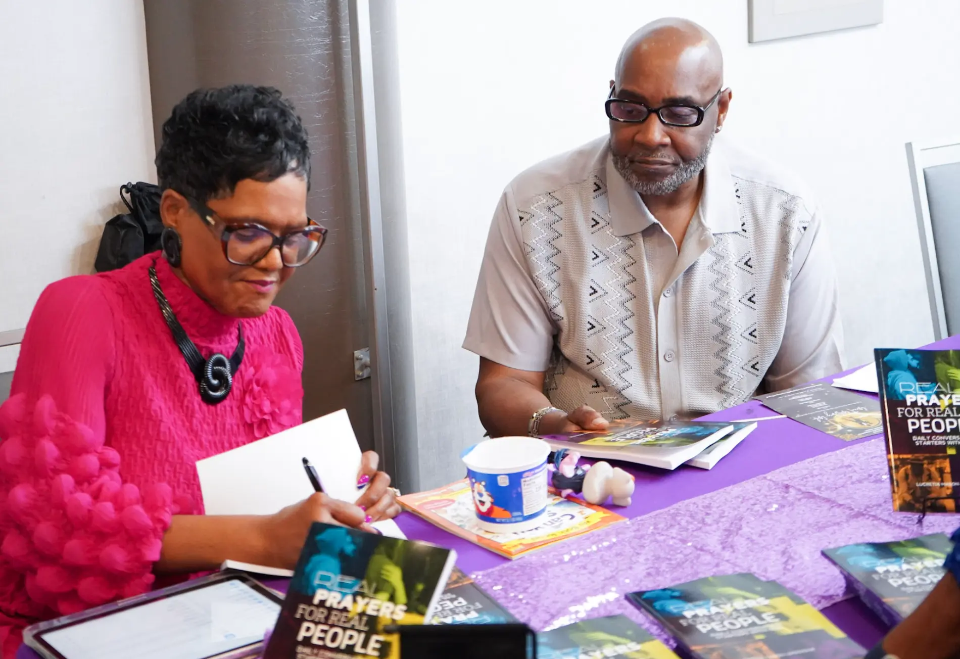 Dr. Lucretia signing copies of Real Prayers for Real People