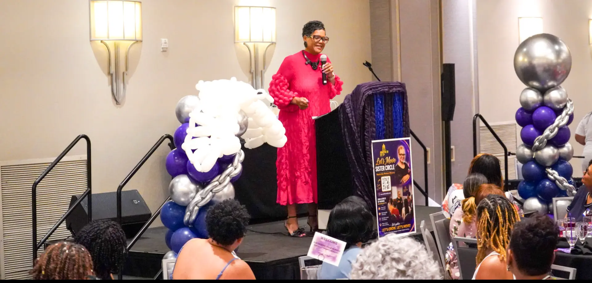 Dr. Lucretia at the podium beside the Let's Move Sister Circle banner